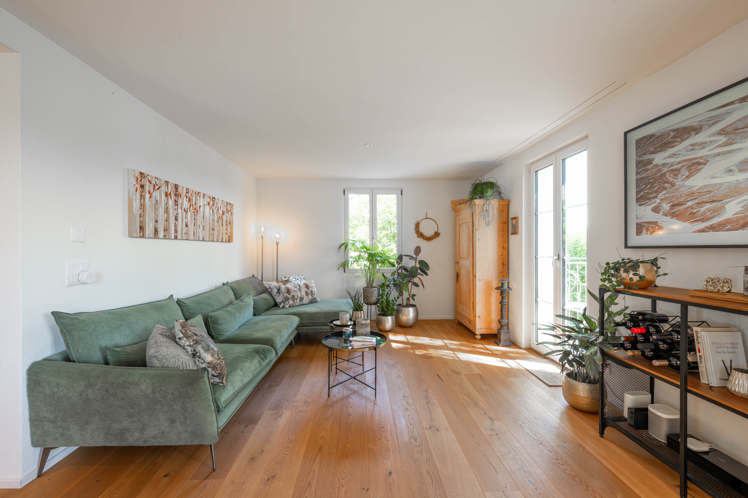 Helles Wohnzimmer mit Pflanzen und Holzboden