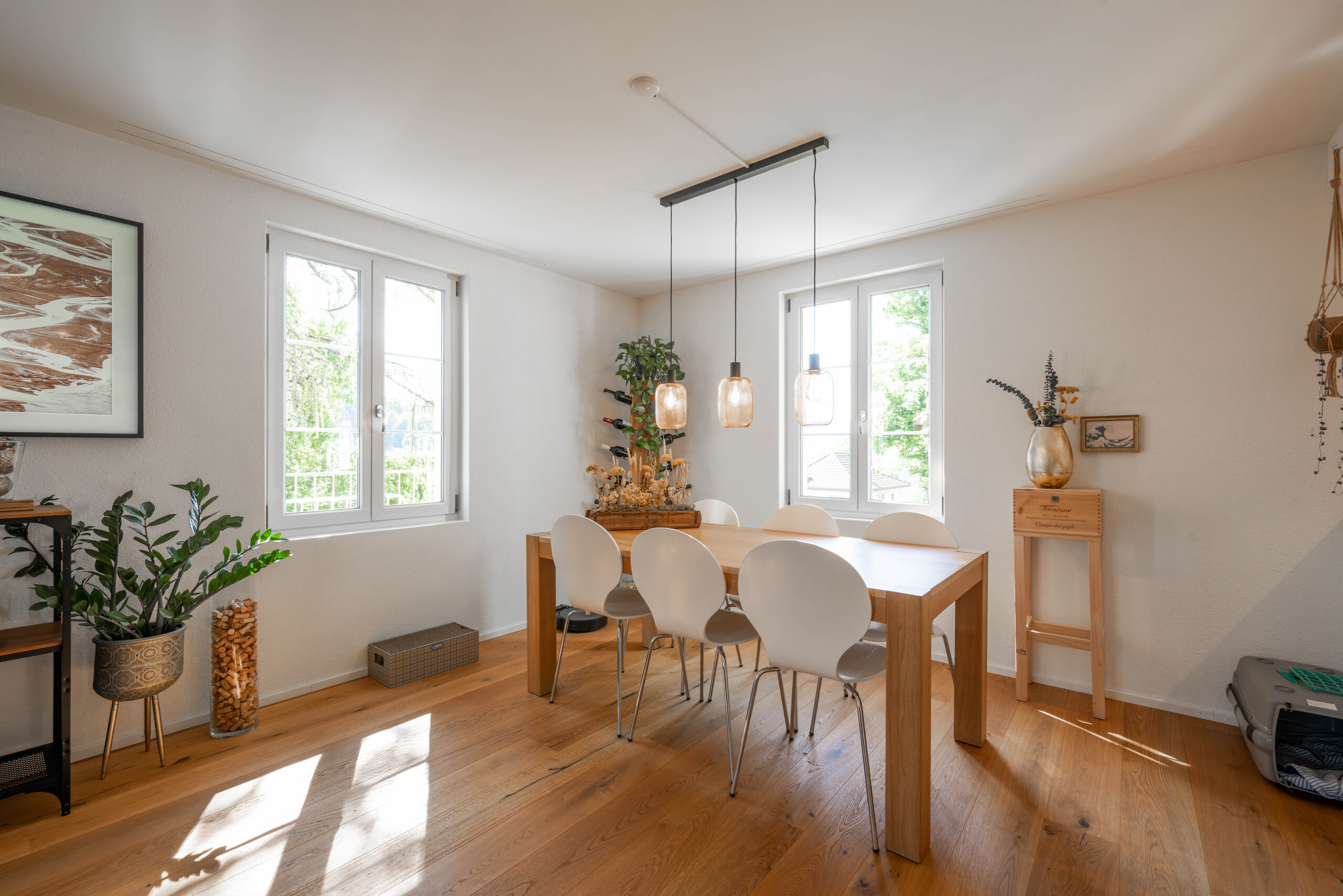 Heller Essbereich mit Holztisch und Pendelleuchten