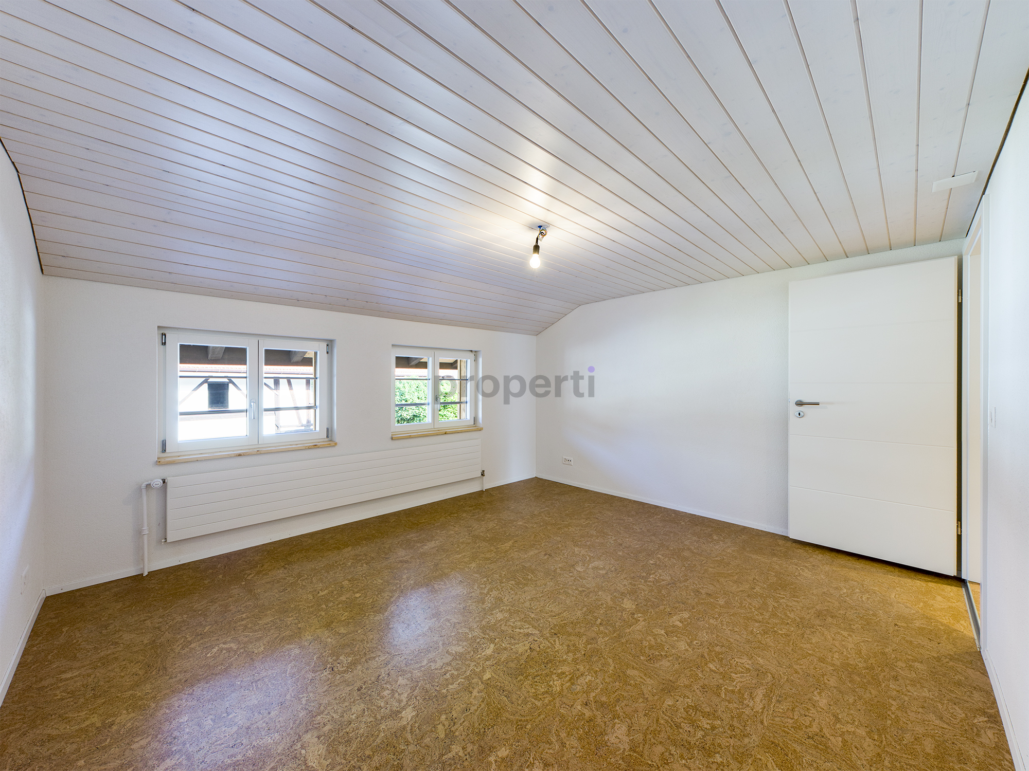 Heller leerer Raum mit gewölbter Holzdecke