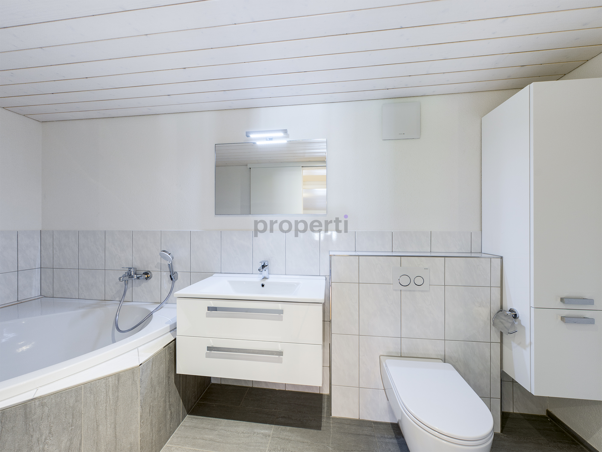 Helles Badezimmer mit Wanne, Waschtisch und WC