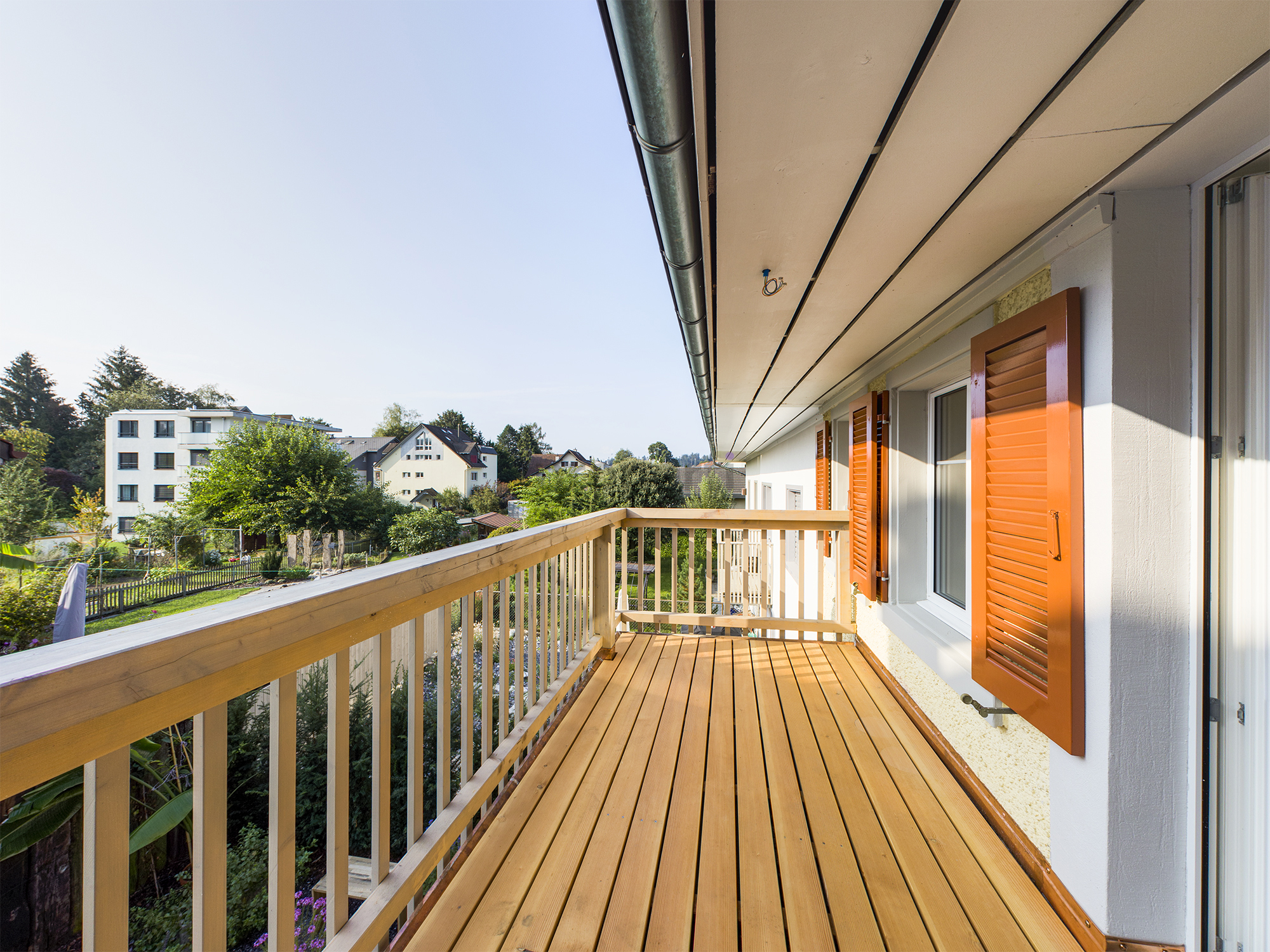 Balkon mit Holzbelag und Blick ins Grüne