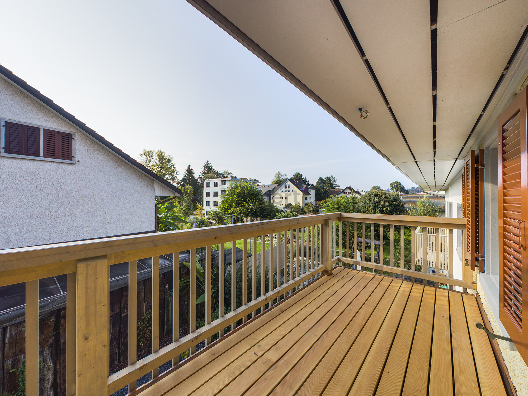 Balkon mit Holzgeländer und Blick ins Grüne