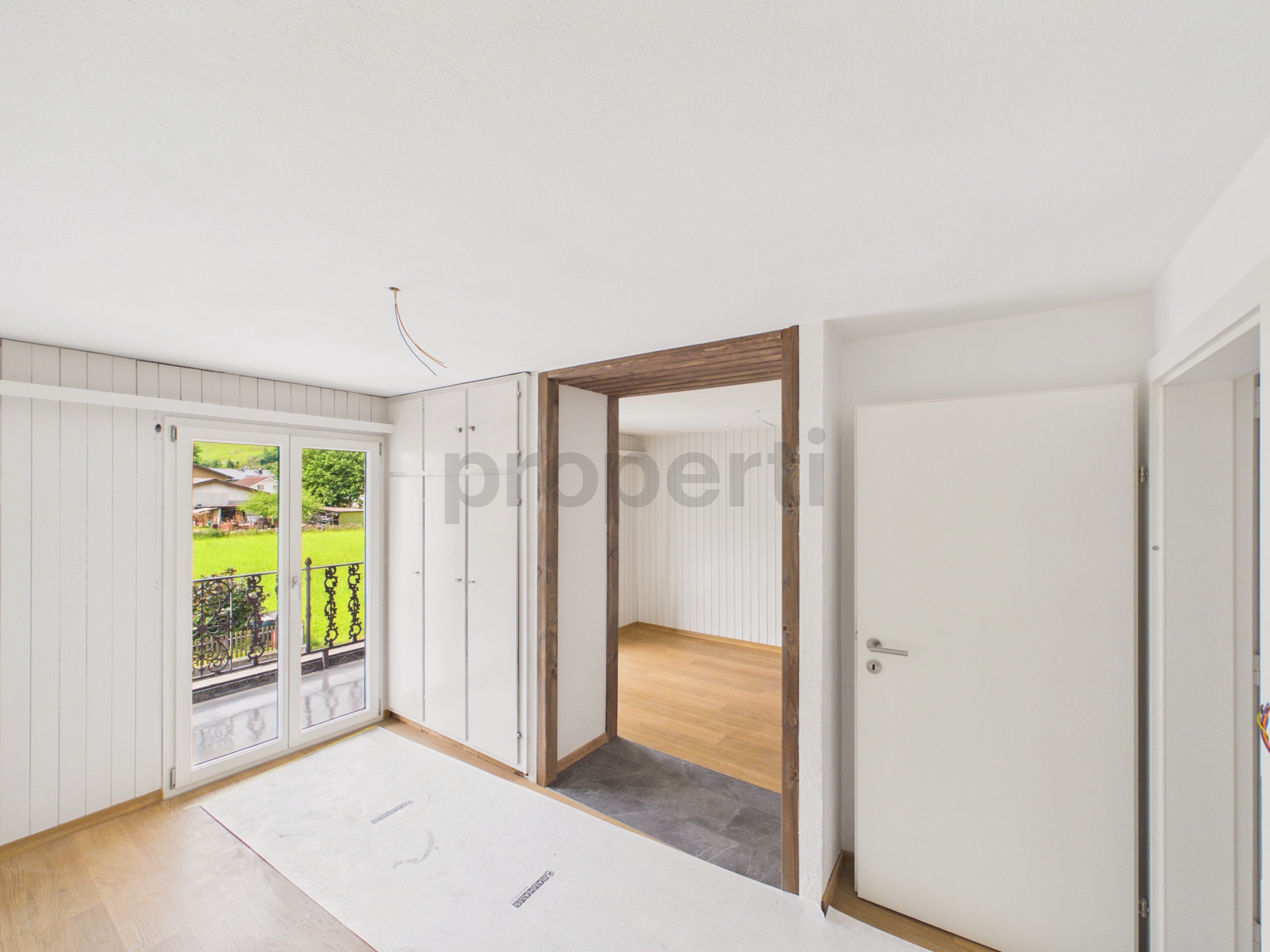 Heller Innenraum mit Balkonblick und Türen