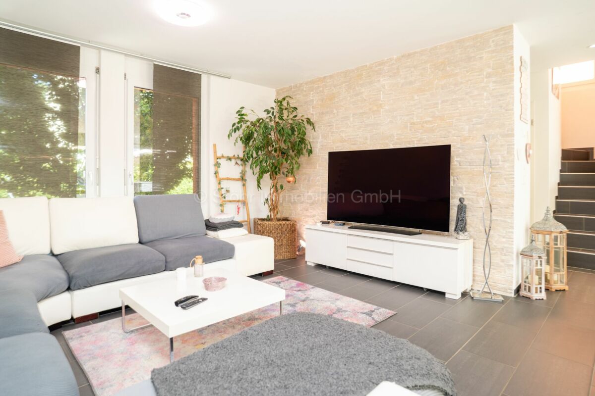 Helles Wohnzimmer mit TV-Wand und Ecksofa