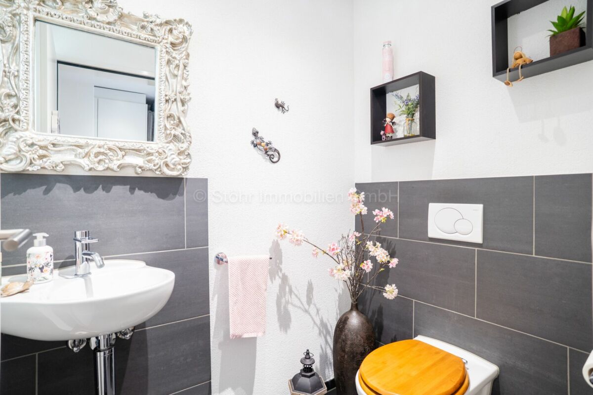 Gäste-WC mit dekorativem Spiegel und Wandwaschbecken
