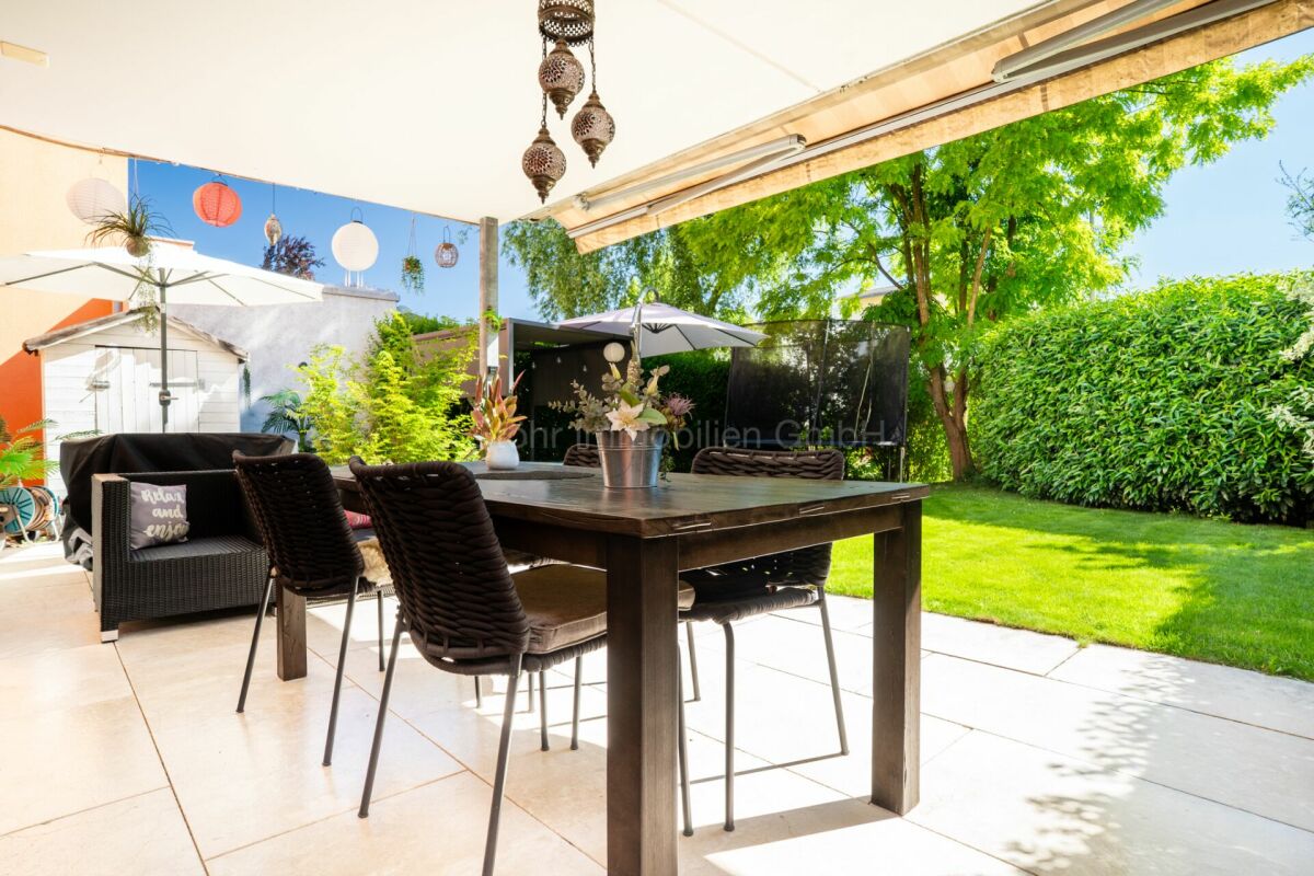 Überdachte Terrasse mit Gartenlounge und Essbereich