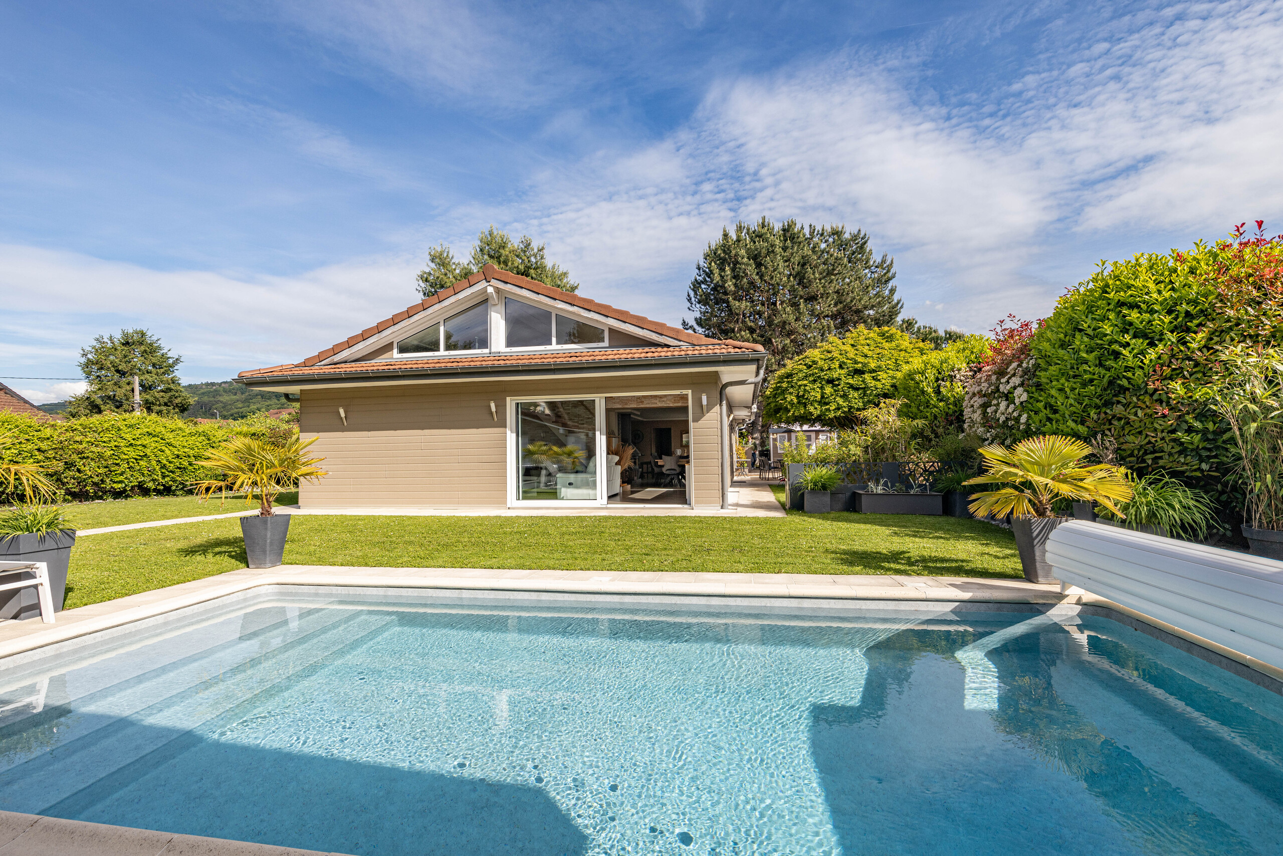 Außenansicht eines Einfamilienhauses mit Pool und Garten