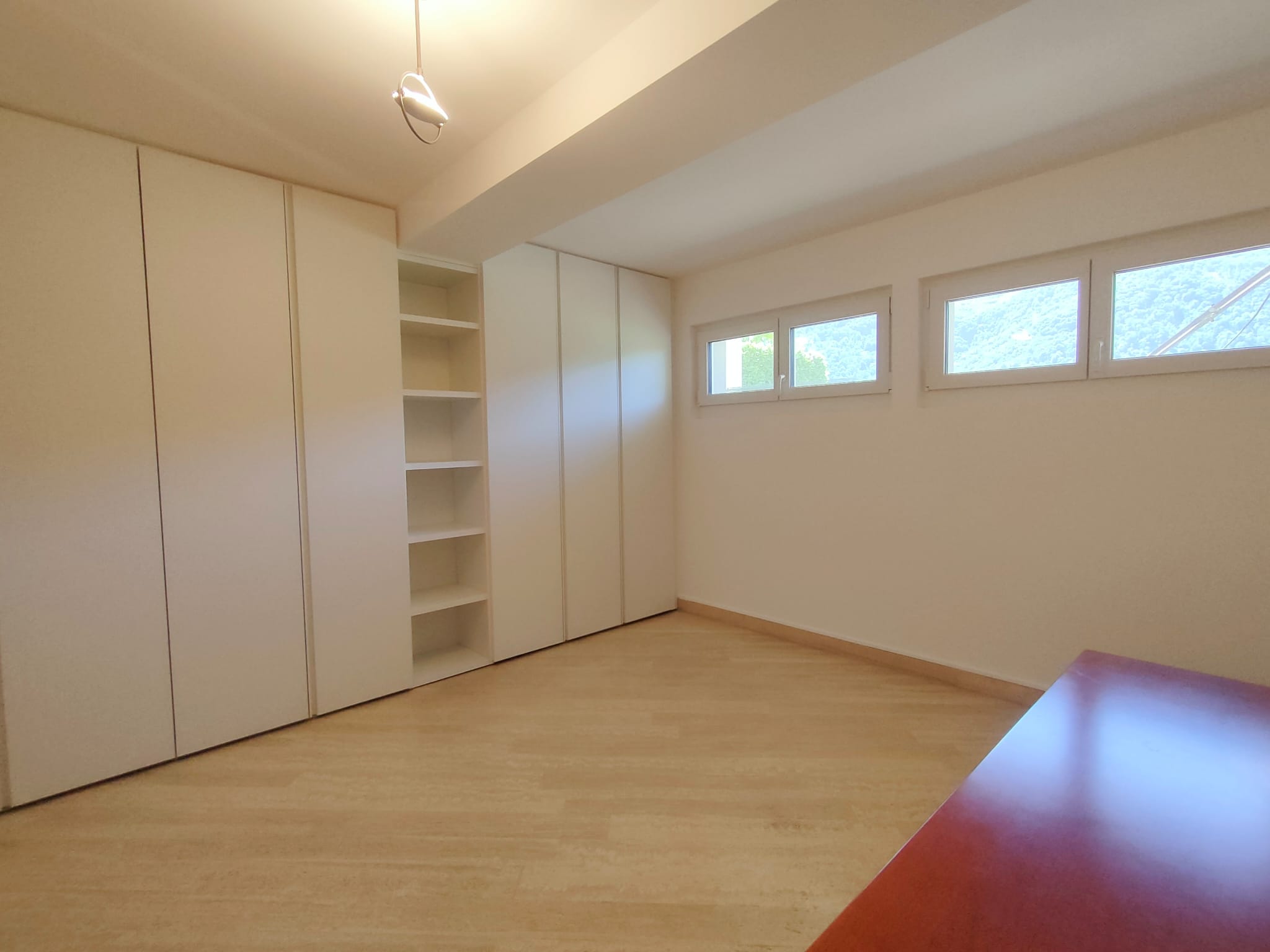 Helles Zimmer mit Einbauschränken und Fenstern