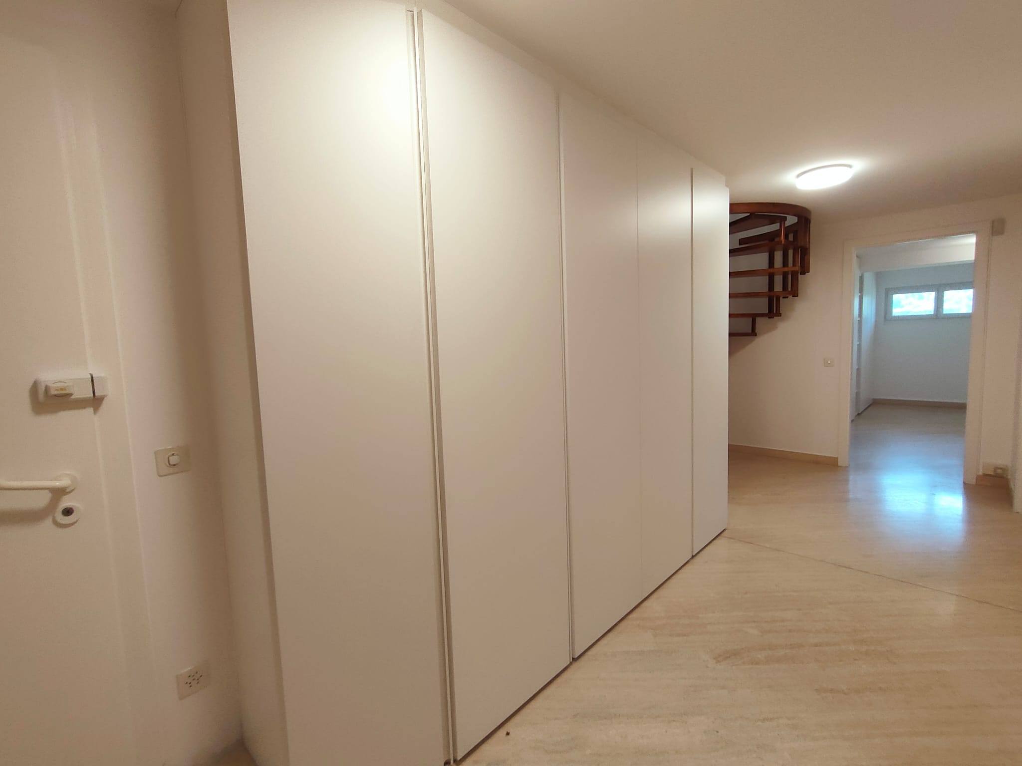Heller Flur mit Einbauschrank und Treppe