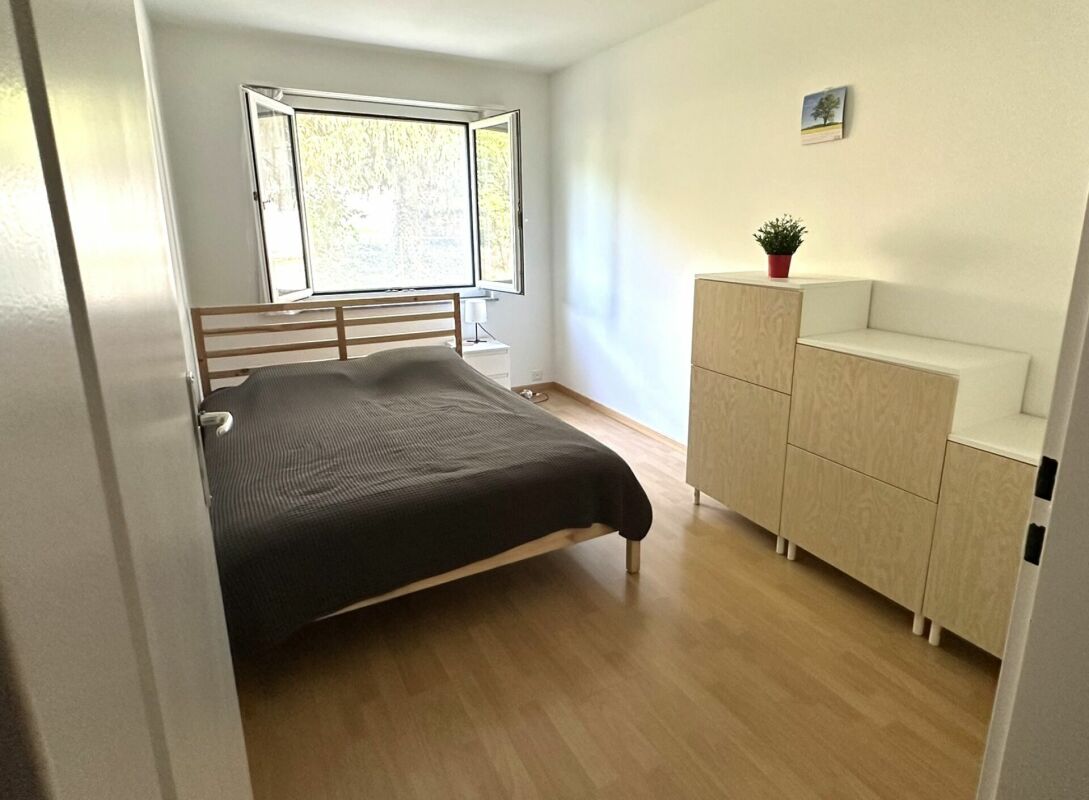 Helles Schlafzimmer mit Fenster und Kommode