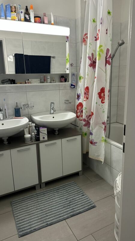 Badezimmer mit Doppelwaschbecken und Duschvorhang