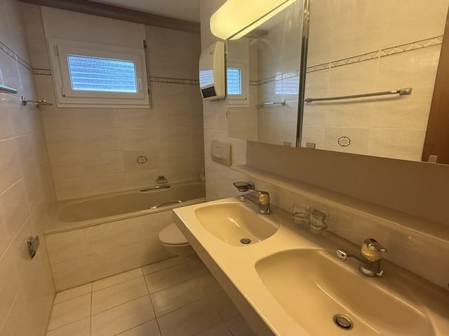 Helles Badezimmer mit Doppelwaschbecken und Badewanne