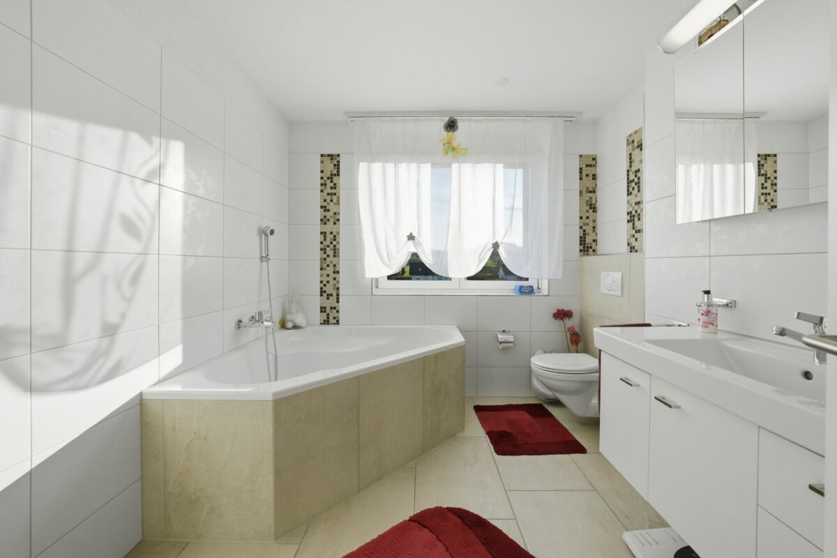 Helles Badezimmer mit Eckbadewanne und Waschtisch