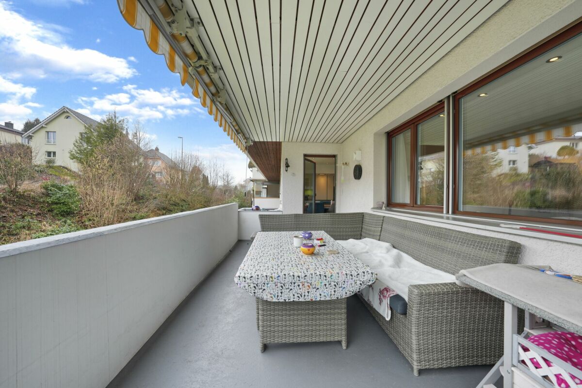 Überdachter Balkon mit Sitzgruppe