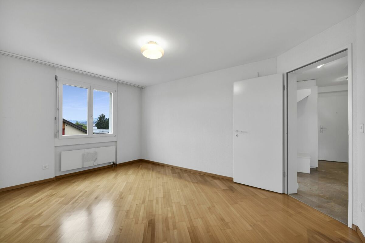 Helles leeres Zimmer mit Fenster und offener Tür