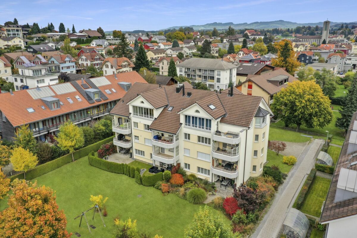 Luftaufnahme eines Wohnquartiers mit Mehrfamilienhaus und Gartenanlage