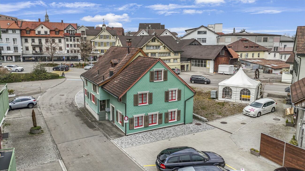 Historische Häuserzeile mit mintgrünem Haus und Zelt im Innenhof