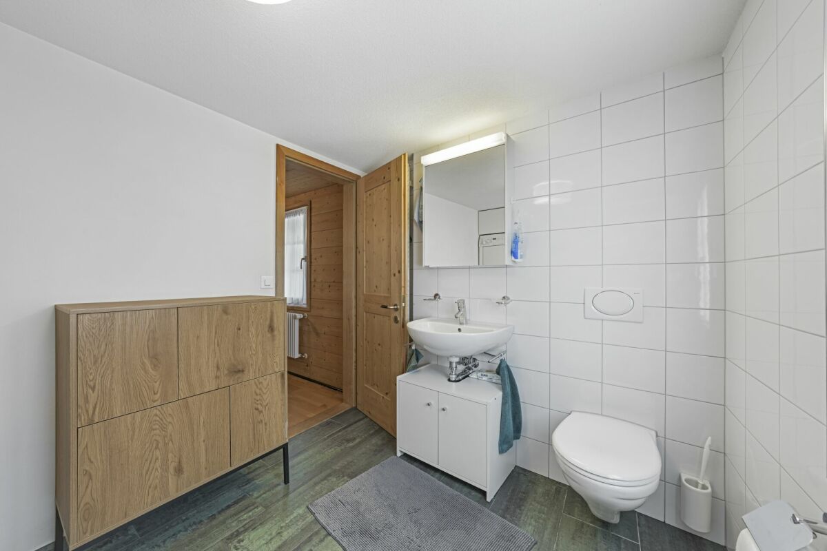 Modernes Gäste-WC mit Holzschrank und Wand-WC