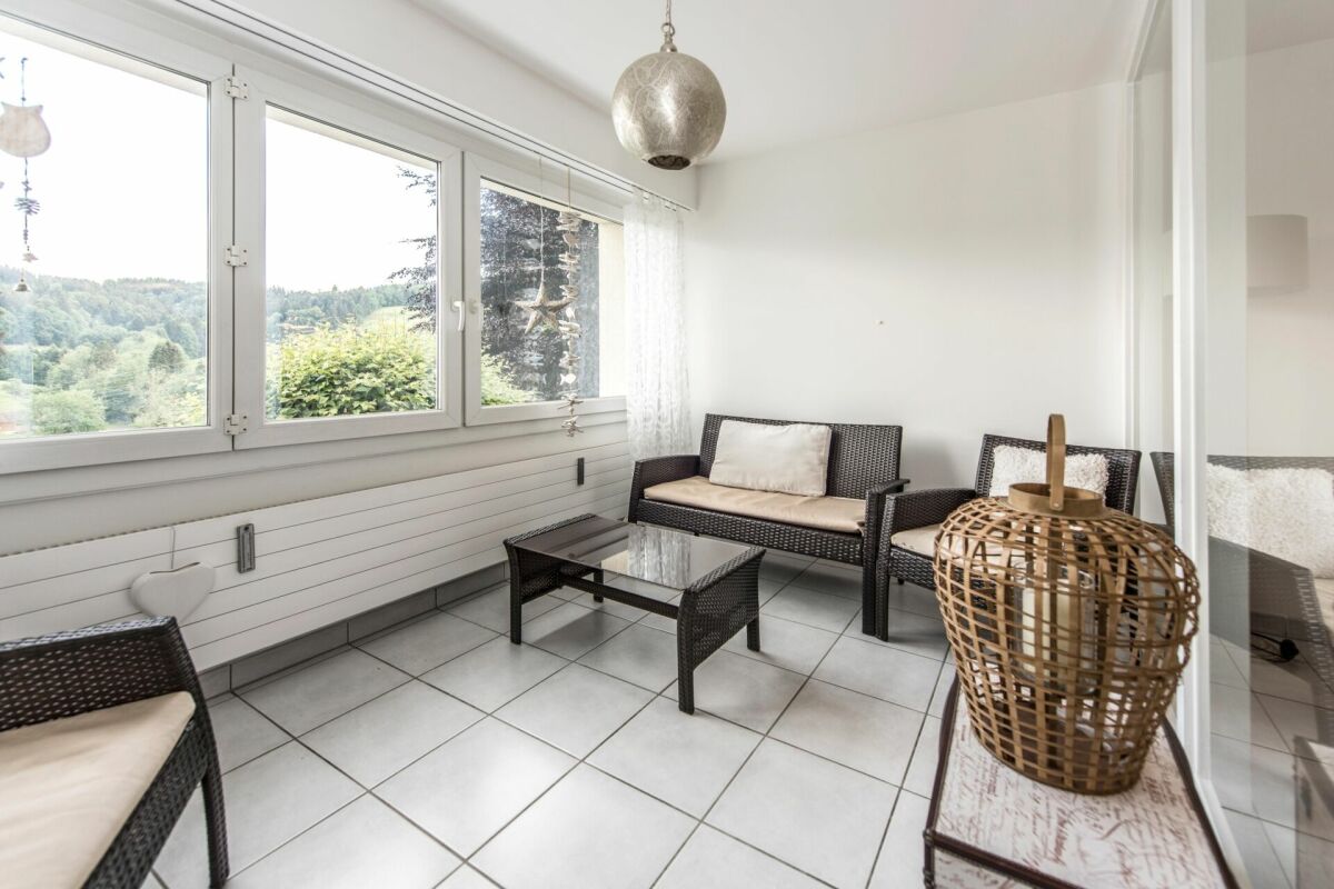 Heller Sitzraum mit großem Fenster und Blick ins Grüne