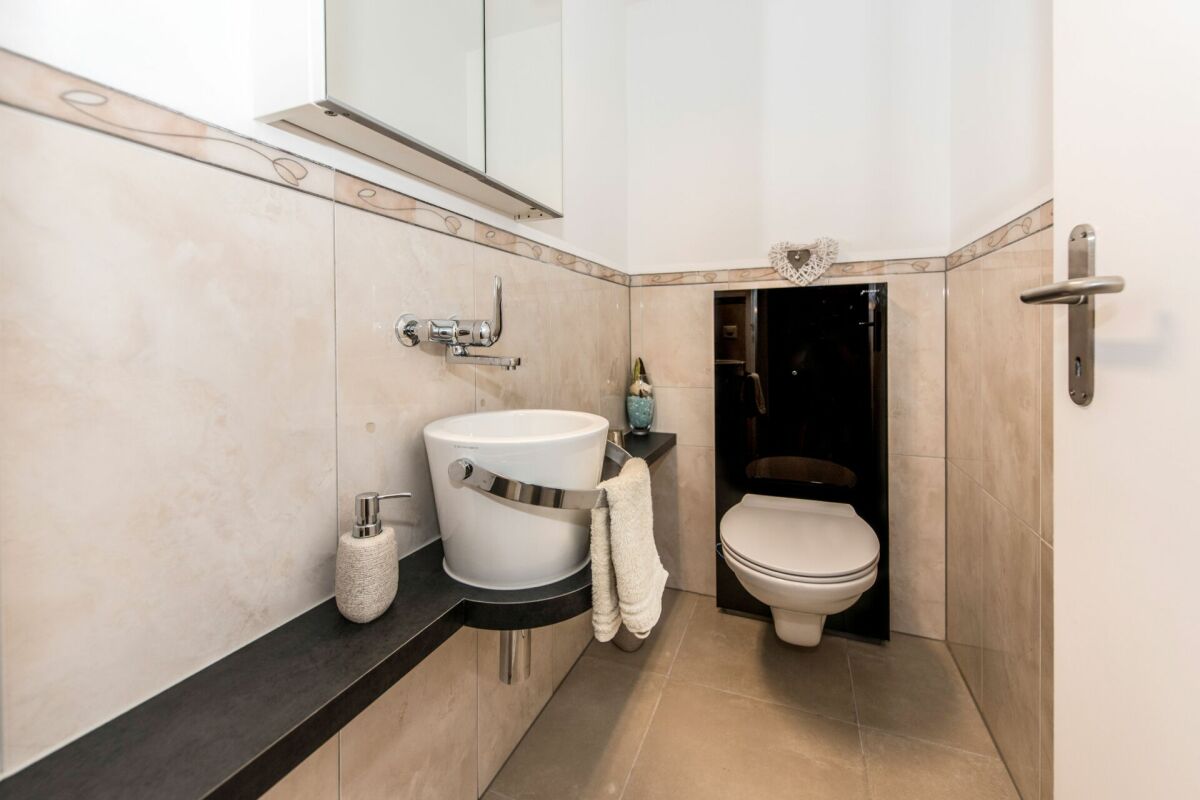 Modernes Gäste-WC mit Wand-WC und Ablagefläche