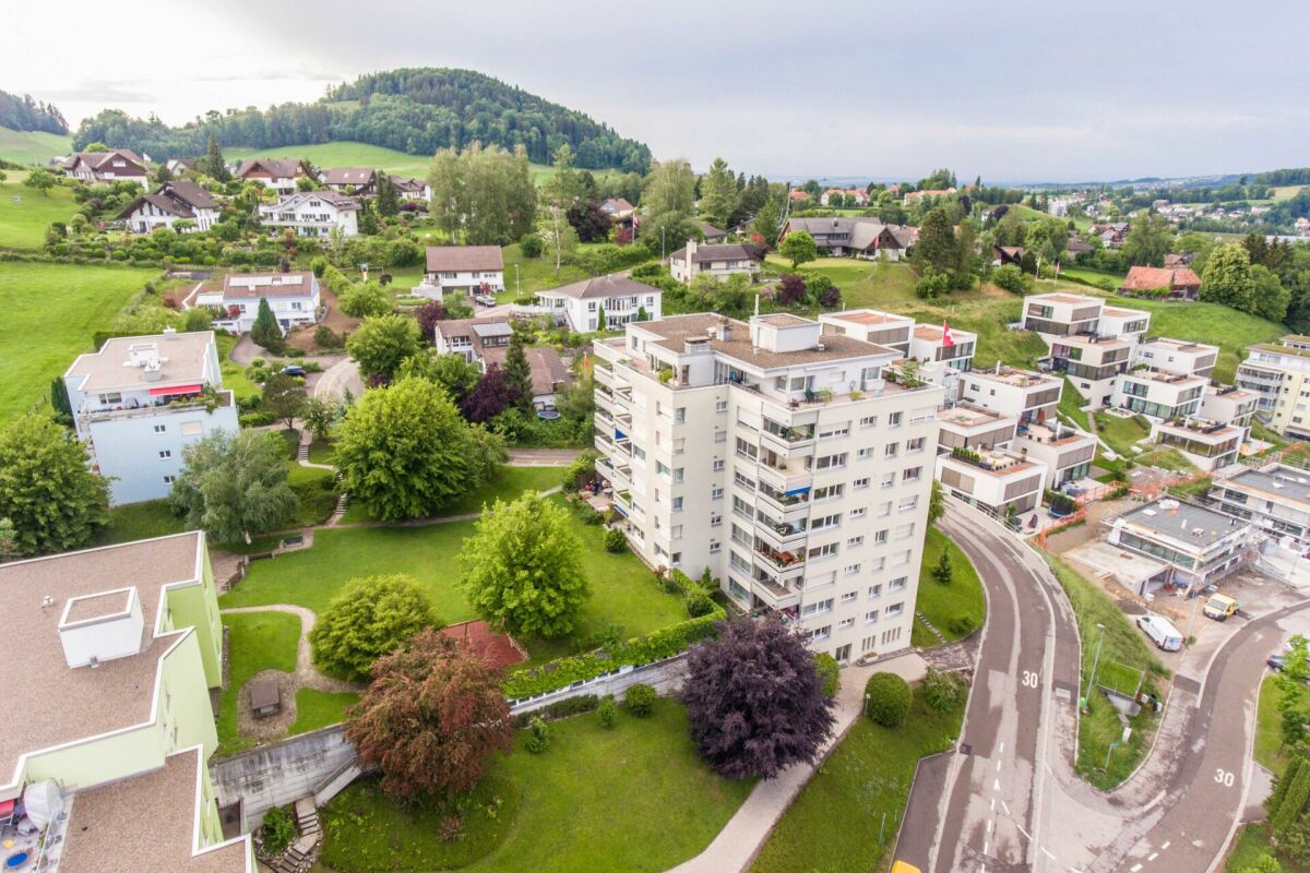 Luftaufnahme einer Wohnanlage in grüner Hügellandschaft