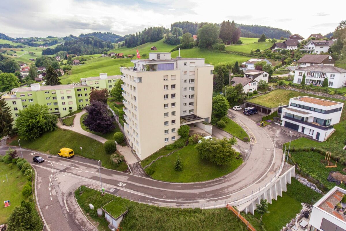 Luftaufnahme eines Wohnviertels in hügeliger Landschaft