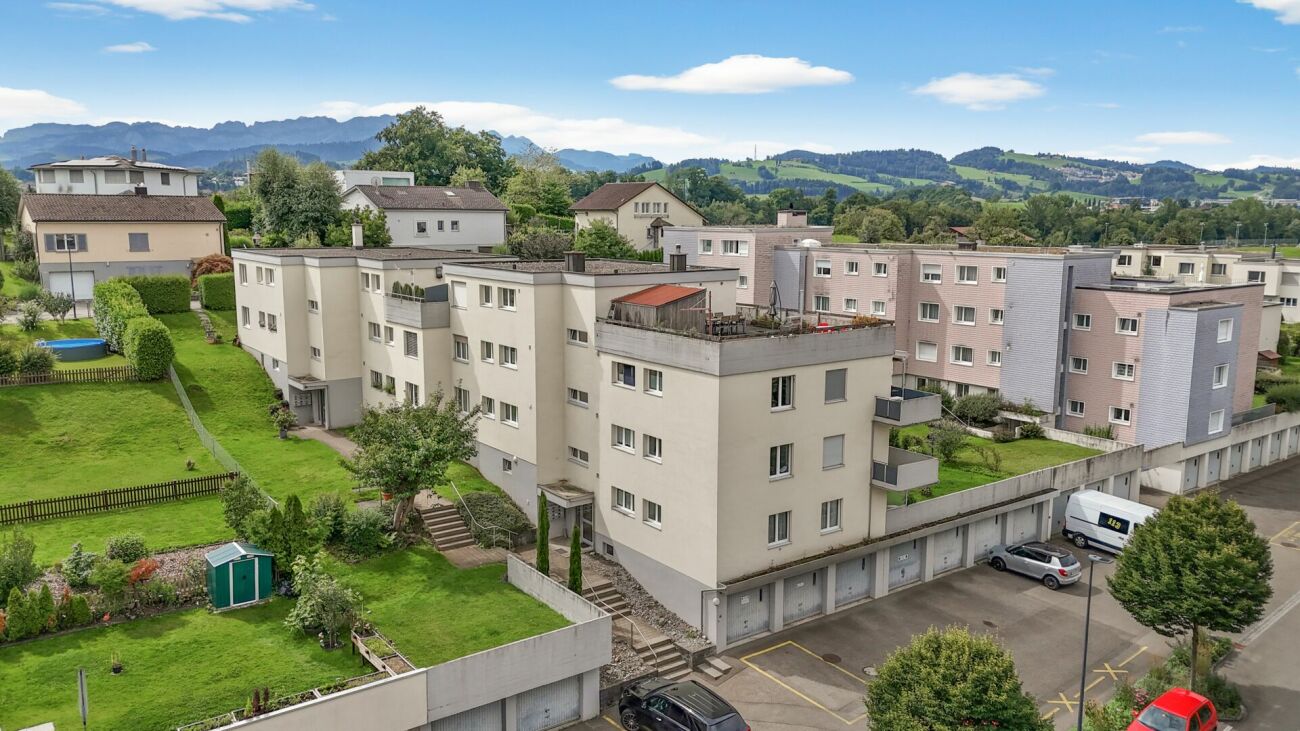 Mehrfamilienhausanlage mit Grünflächen und Bergblick