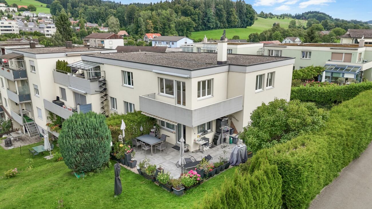 Außenansicht eines Mehrfamilienhauses mit Garten und Terrassen