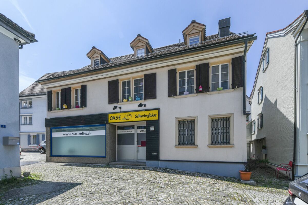 Straßenansicht eines gemischt genutzten Altbaus mit Ladenlokal