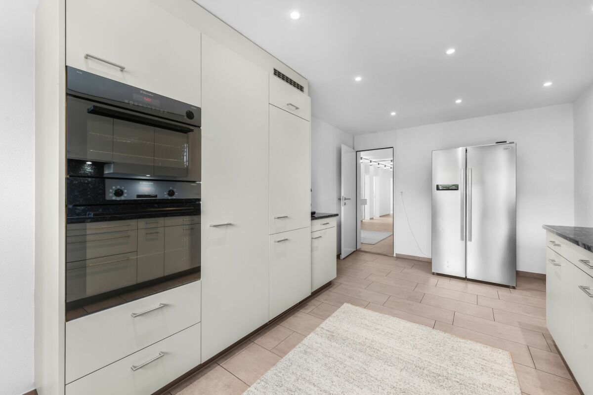 Moderne helle Küche mit großem Kühlschrank und Einbaugeräten