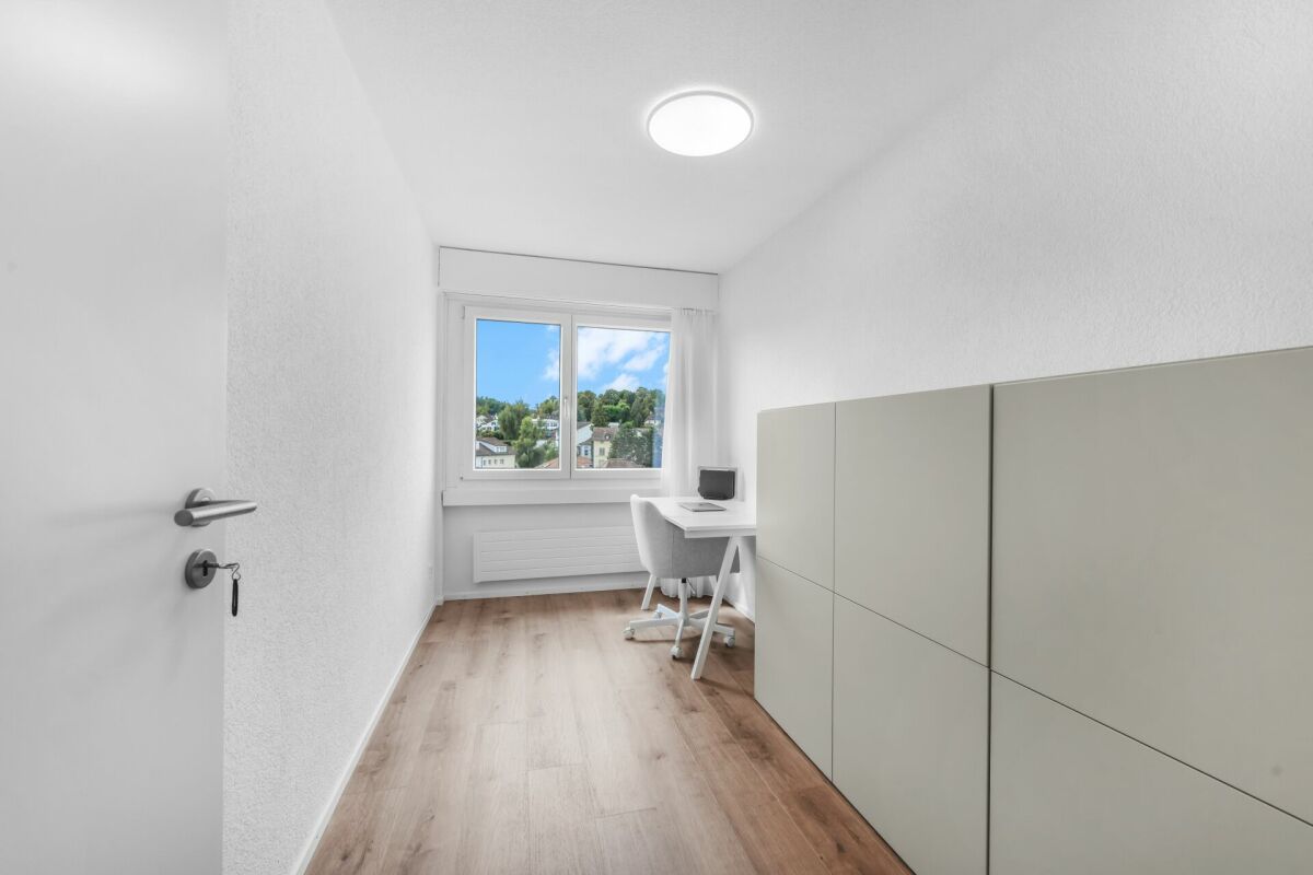 Helles, schmales Arbeitszimmer mit Fenster und Einbauschrank