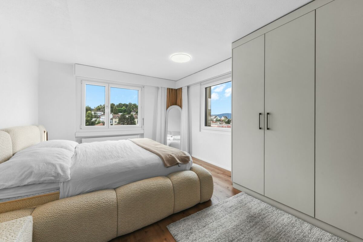 Helles Schlafzimmer mit zwei Fenstern und großem Kleiderschrank