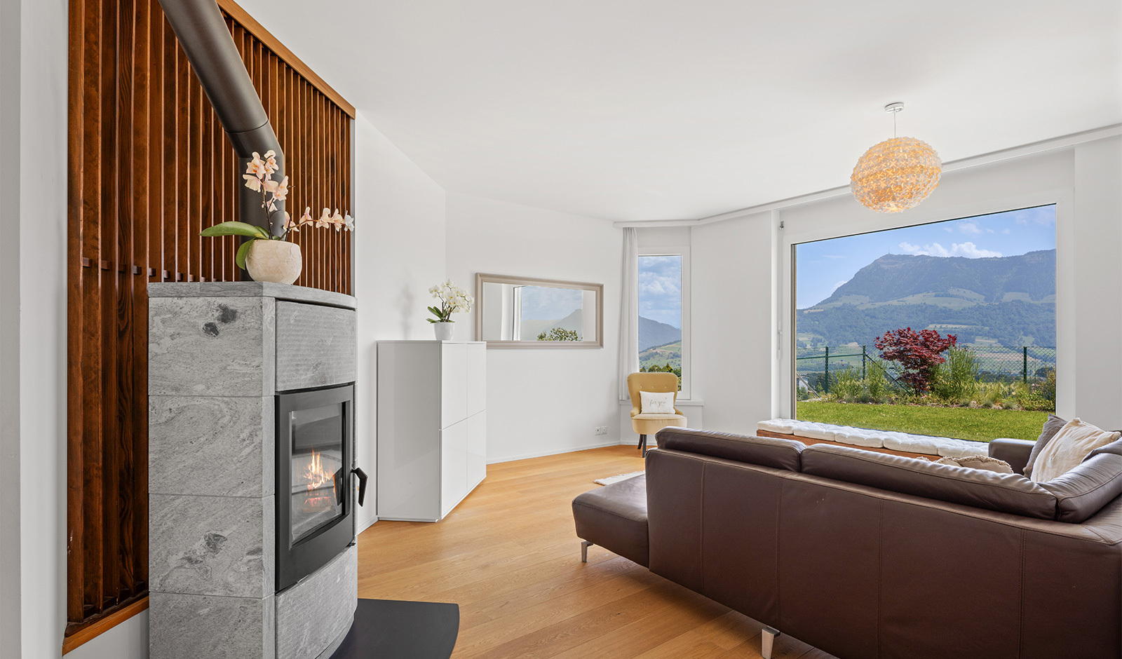 Wohnzimmer mit Kamin und Bergblick