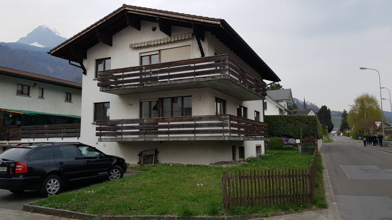 Mehrfamilienhaus mit Balkon und Bergkulisse
