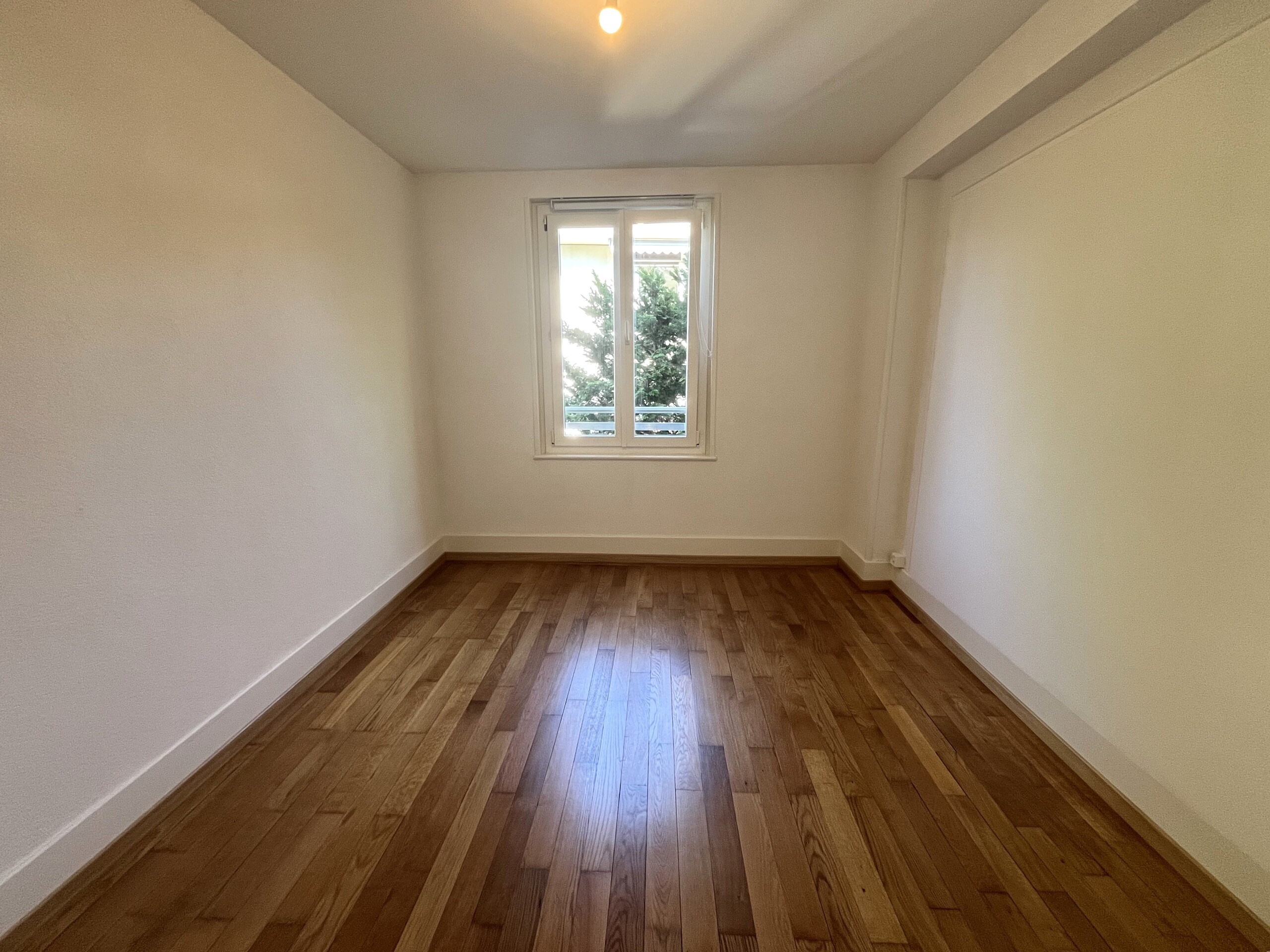 Leerer, heller Raum mit Holzfußboden