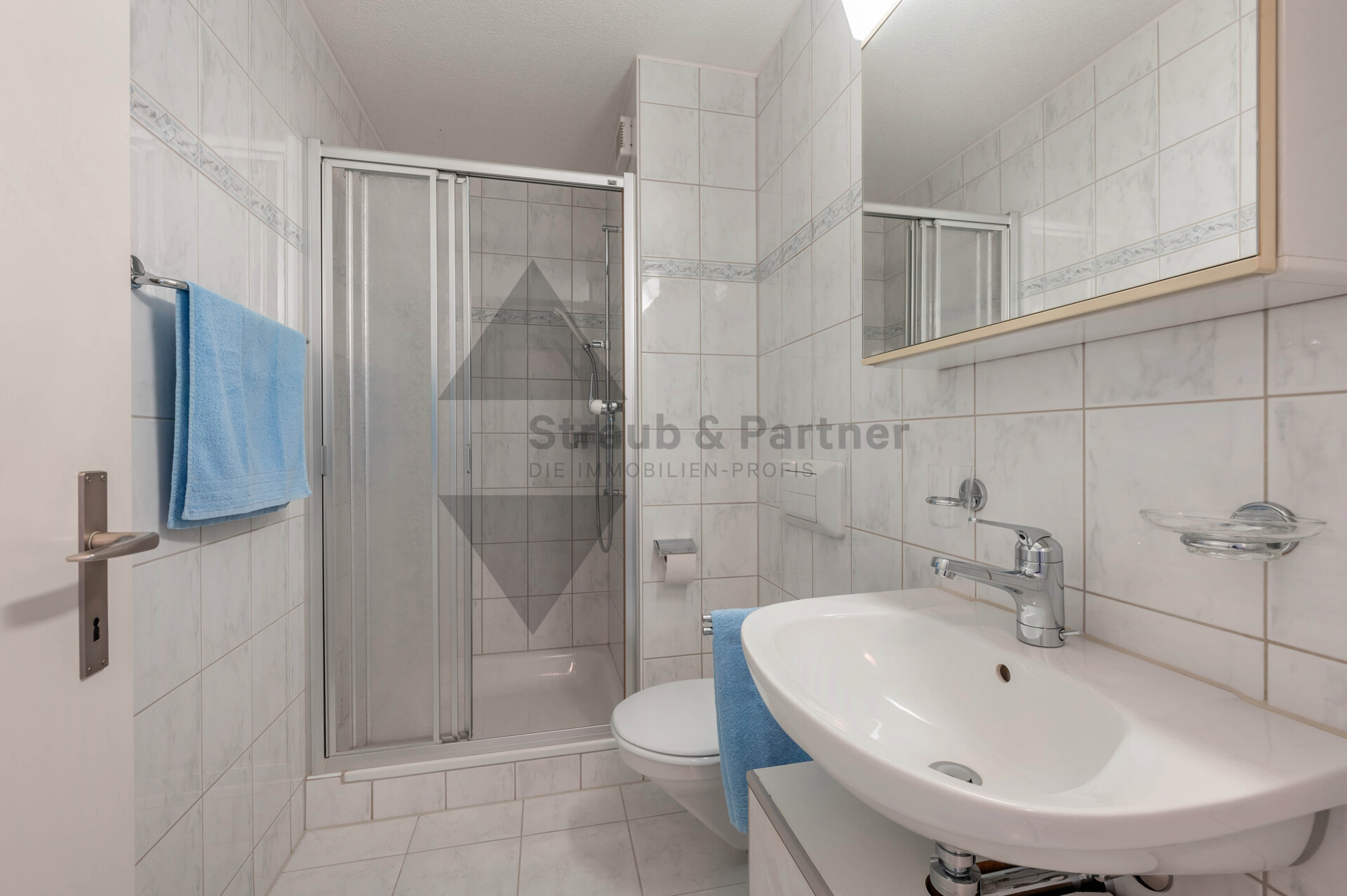 Kleines, helles Badezimmer mit Dusche und Waschbecken