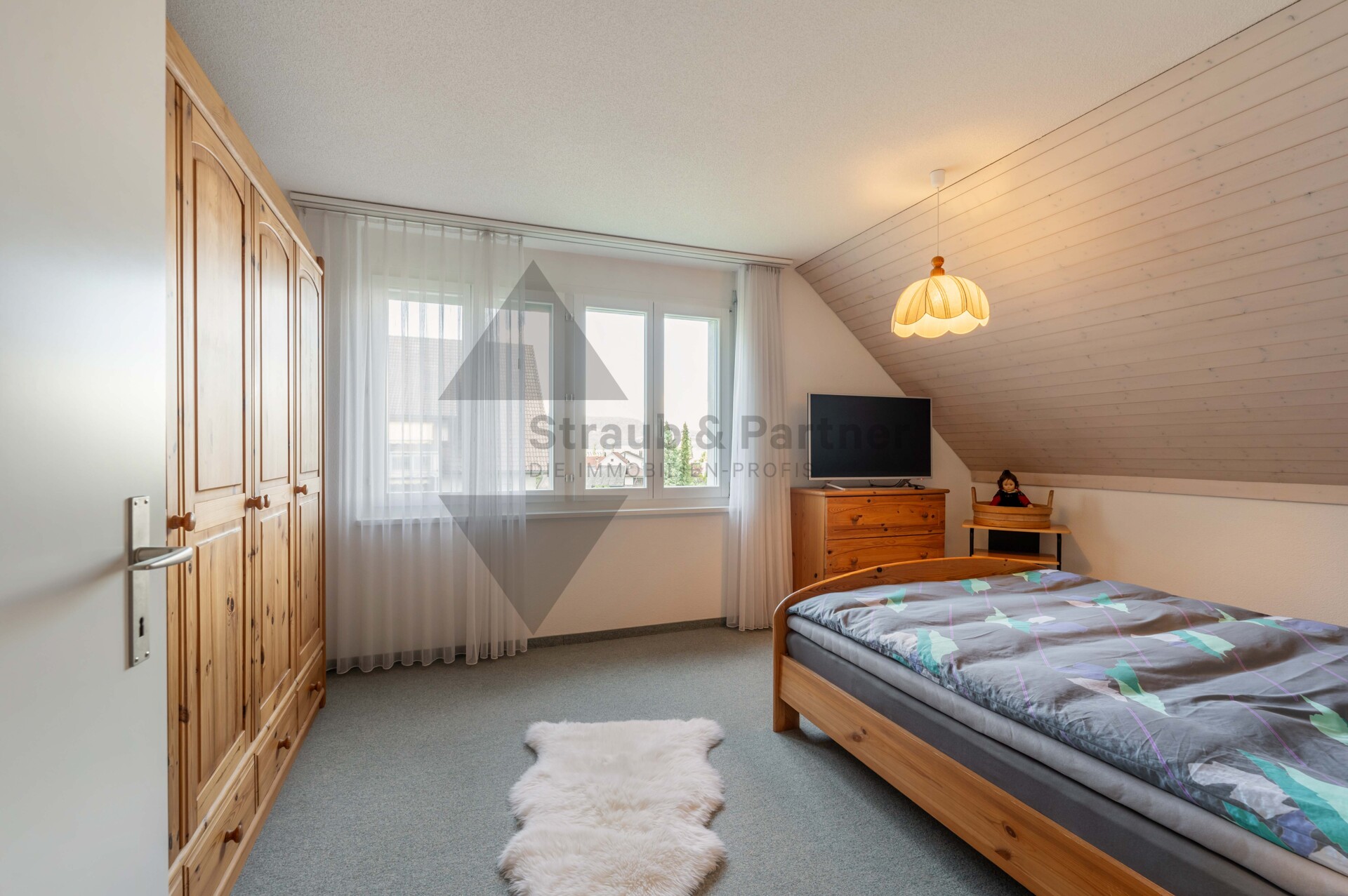 Dachgeschoss-Schlafzimmer mit Schrank und Einzelbett