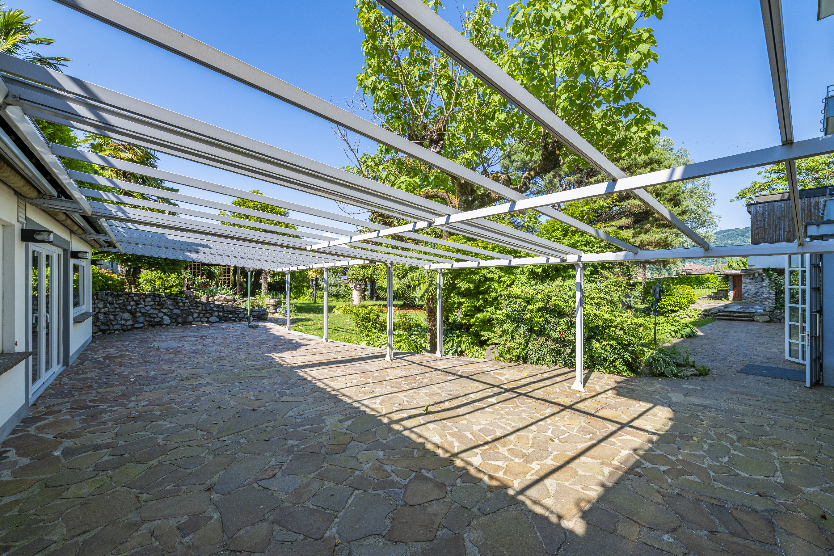 Überdachte Terrasse mit Pergola und Gartenblick