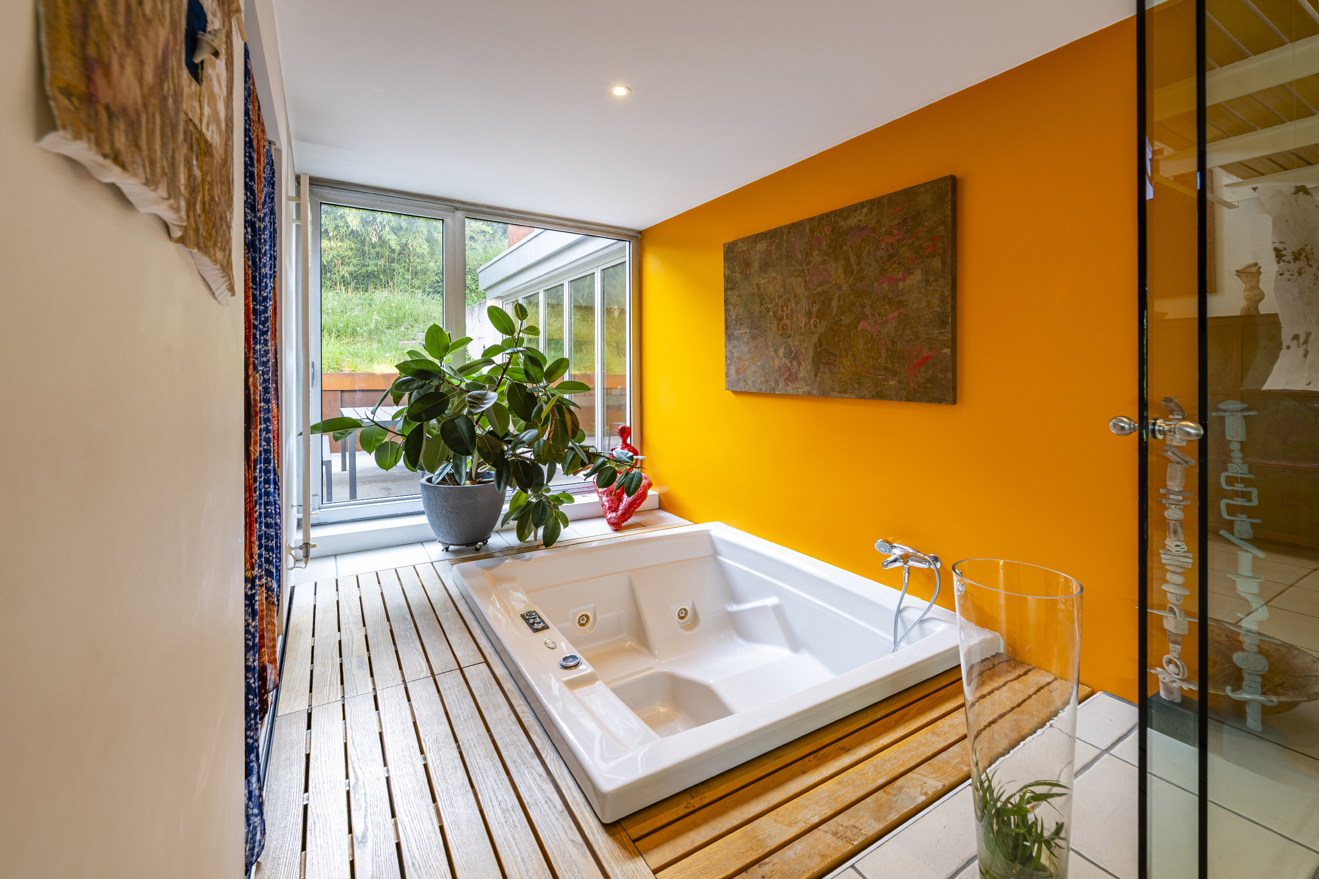 Modernes Badezimmer mit Whirlpool und Blick ins Grün
