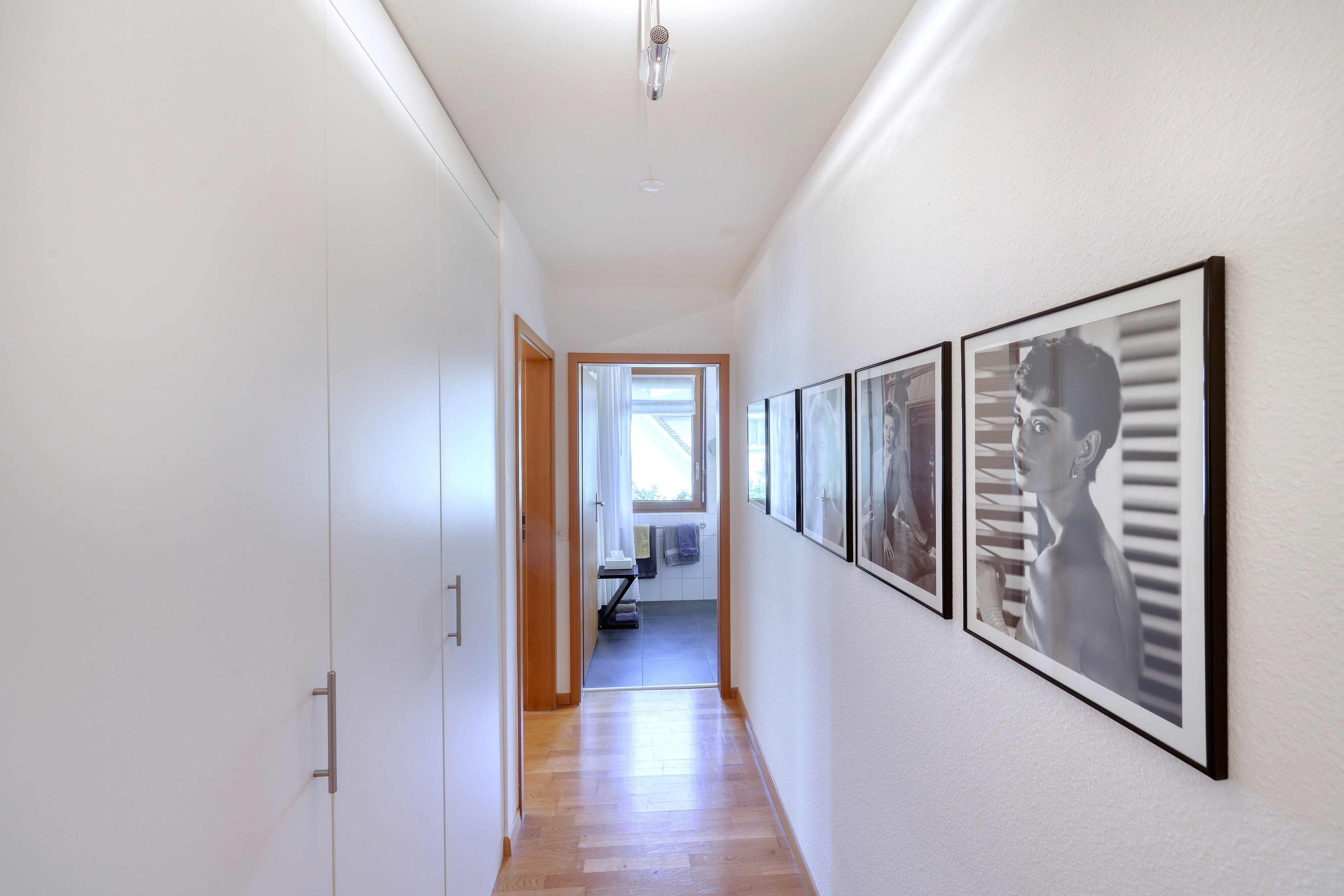 Heller Flur mit Einbauschränken und gerahmten Bildern