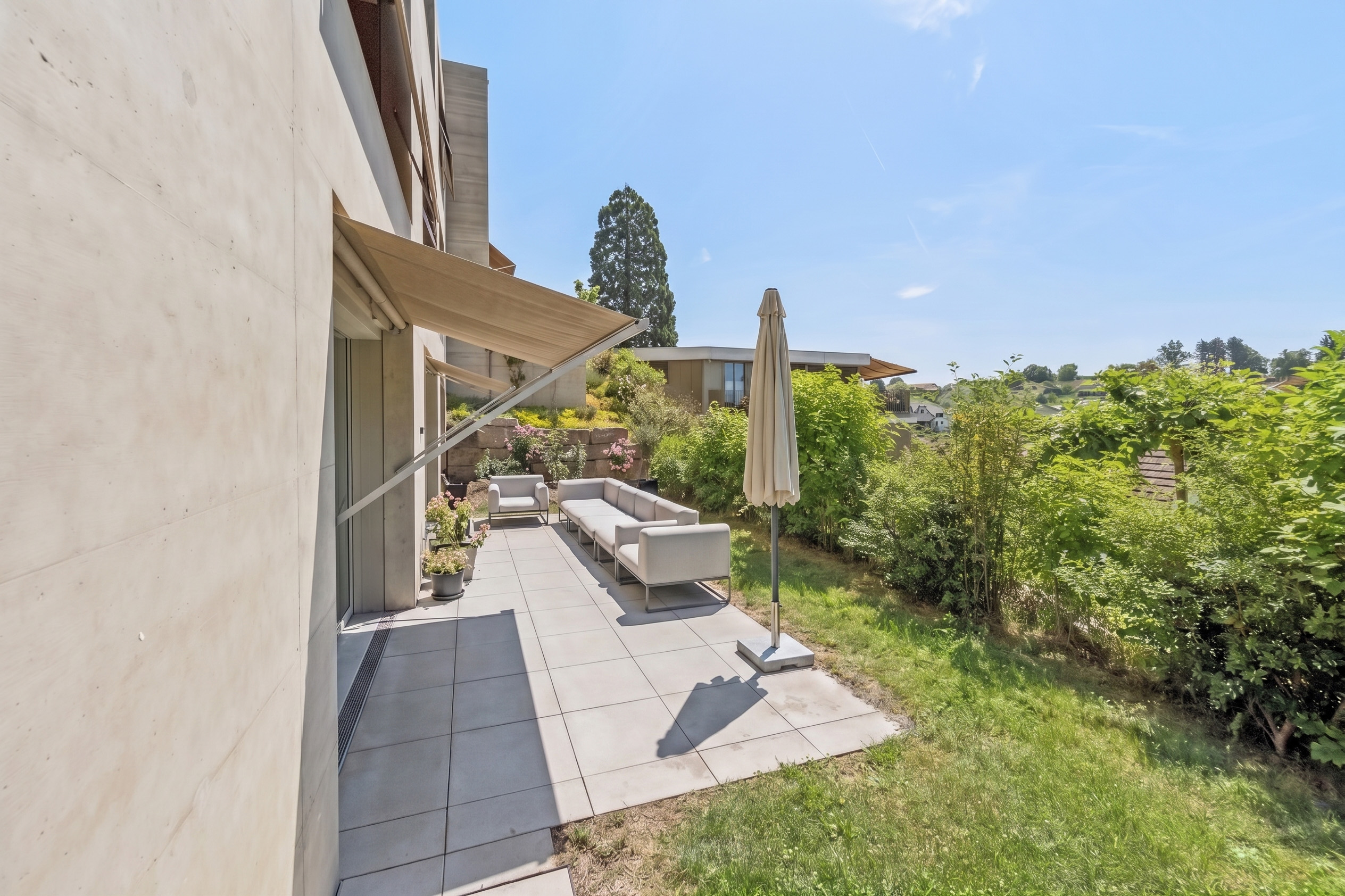 Terrasse mit Lounge-Möbeln und Gartenblick