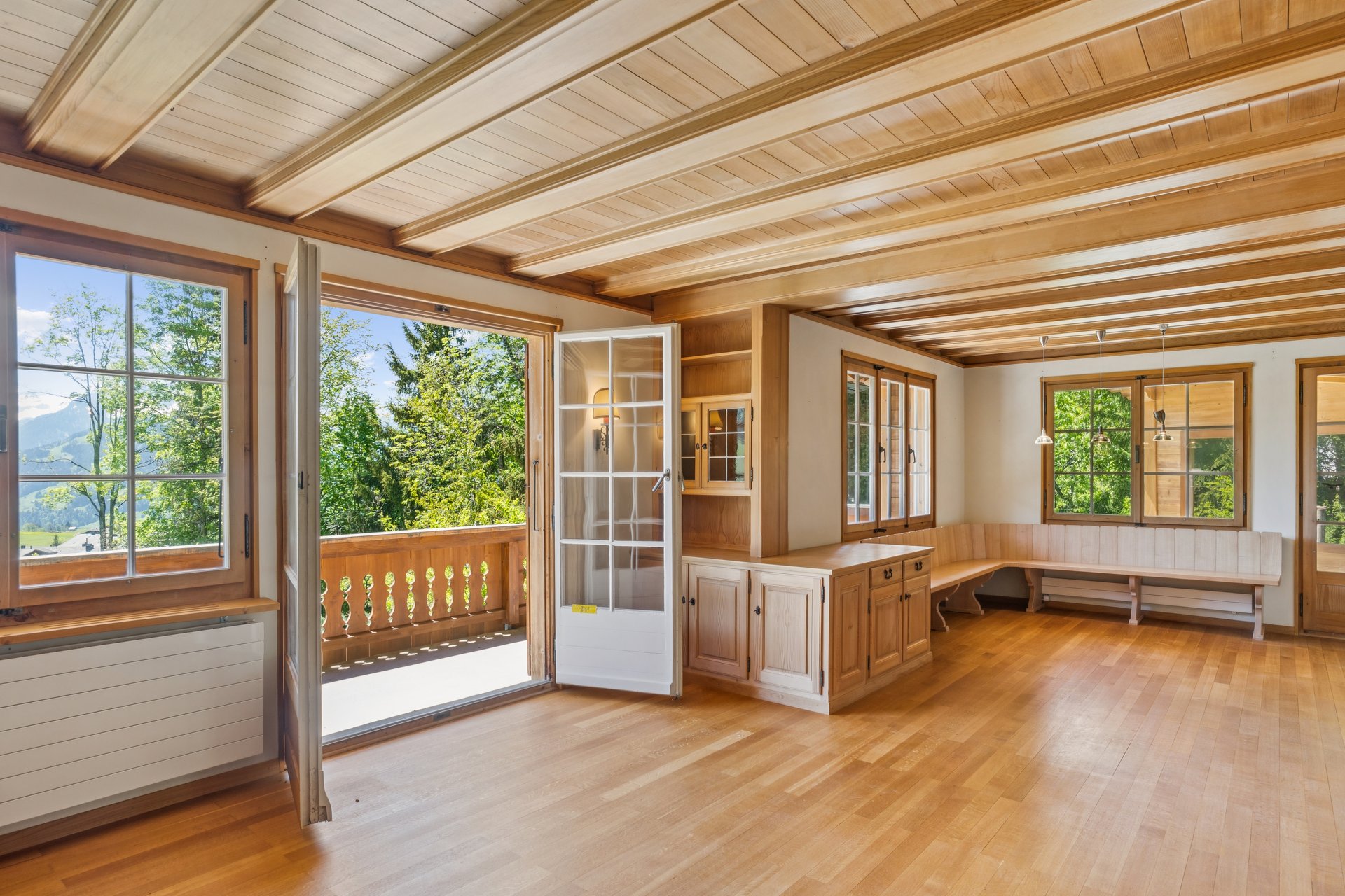 Heller Wohnraum mit Holzausstattung und Balkonzugang