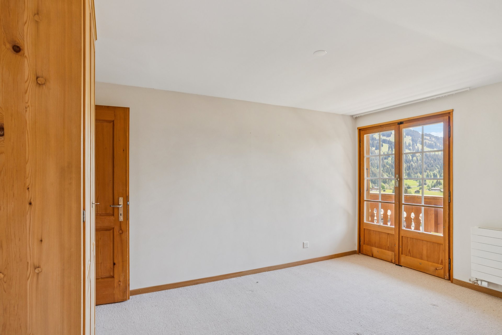 Helles Schlafzimmer mit Bergblick und Holzelementen