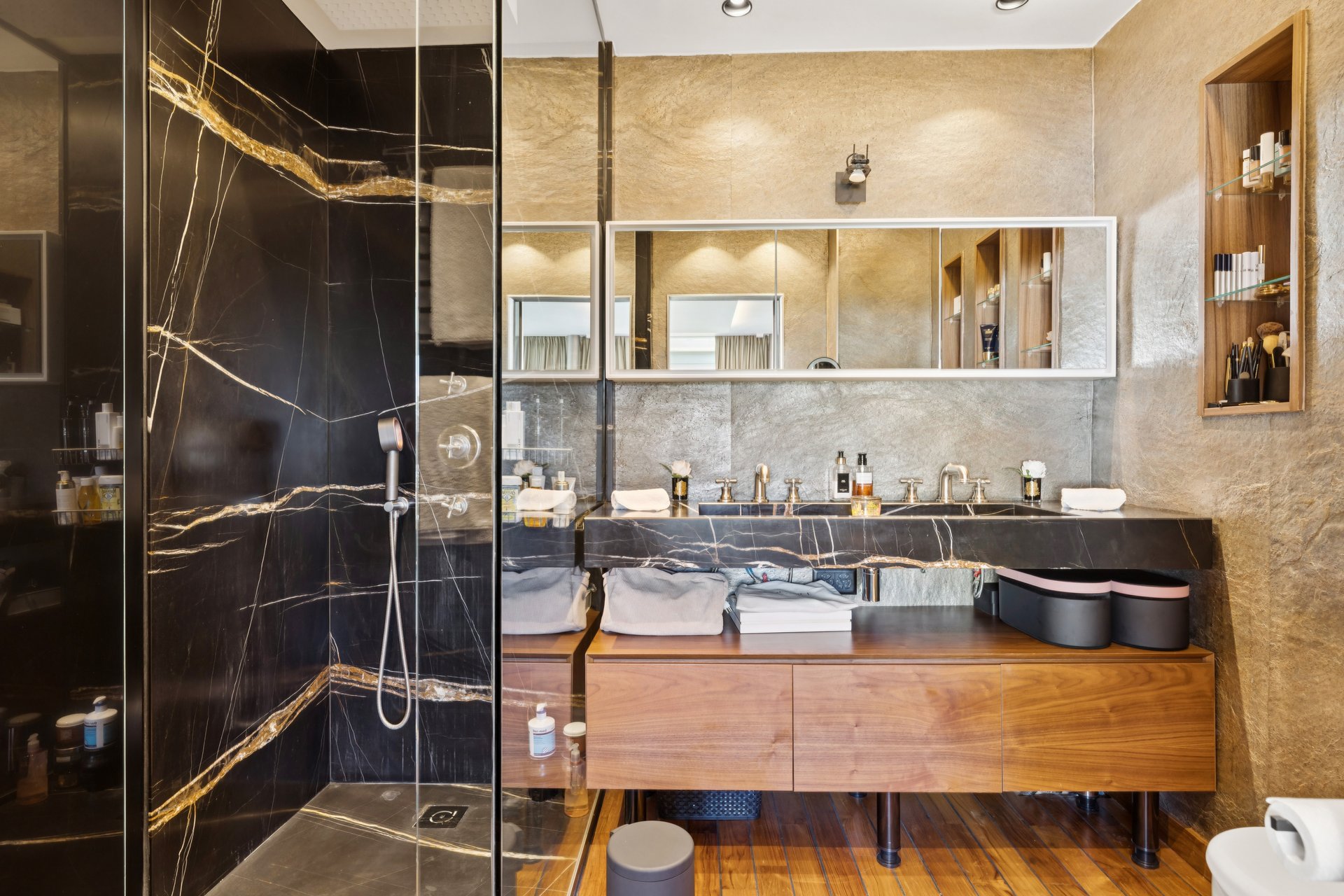 Luxuriöses Badezimmer mit dunkler Dusche und Holzwaschtisch