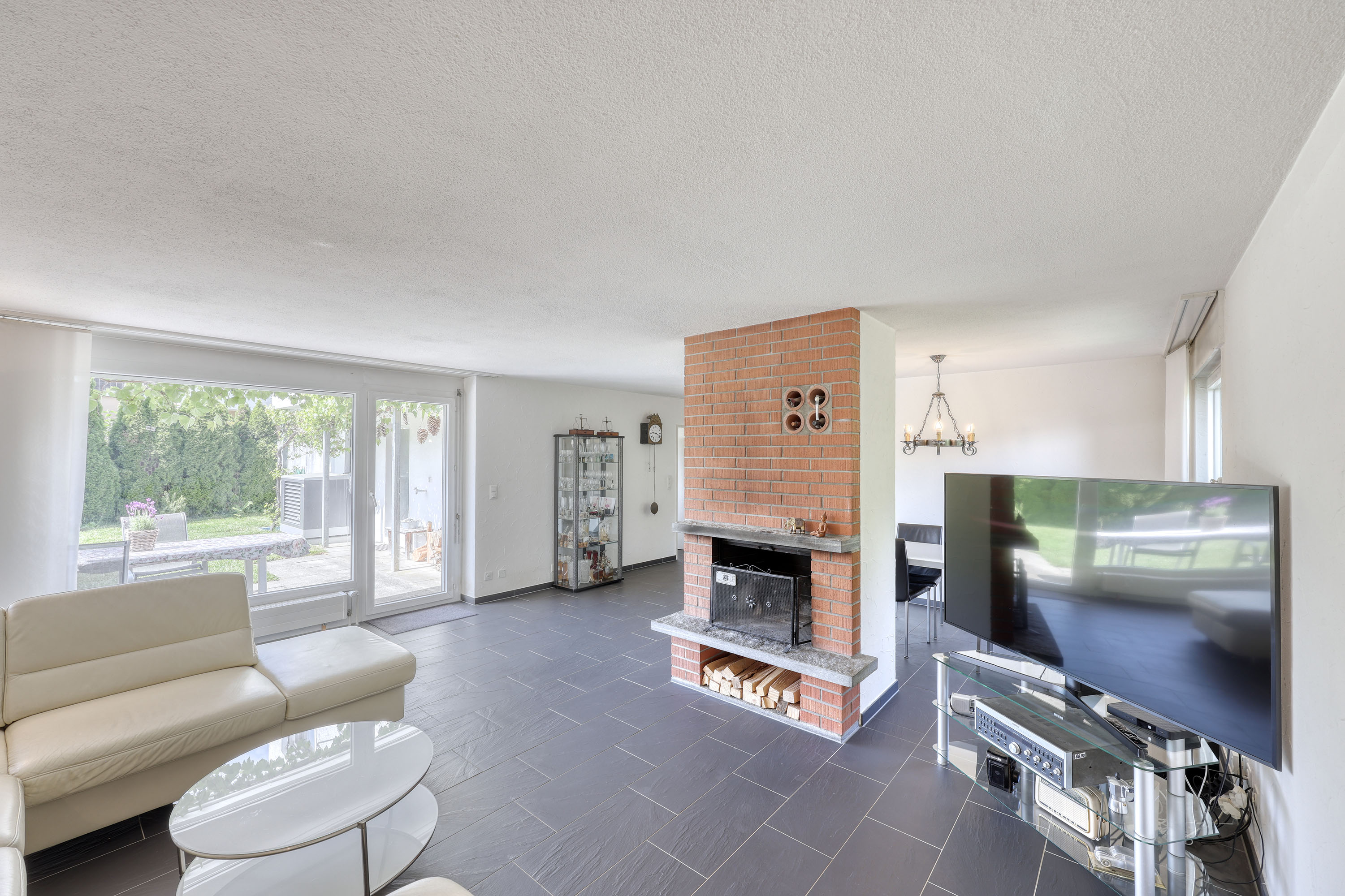 Wohnzimmer mit Kamin und Terrassenzugang