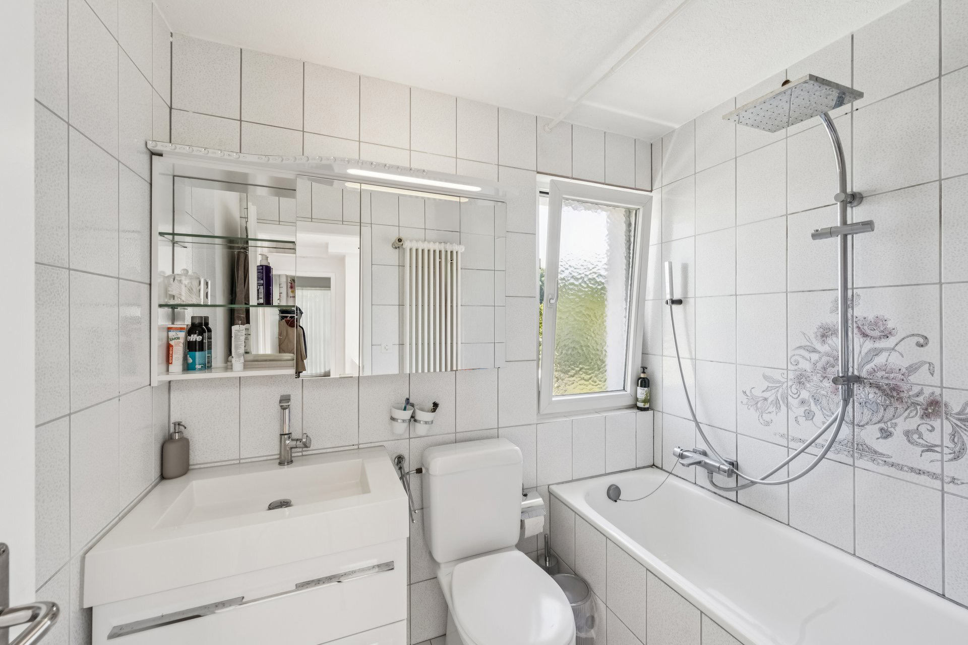 Helles, kompaktes Badezimmer mit Wanne und Dusche