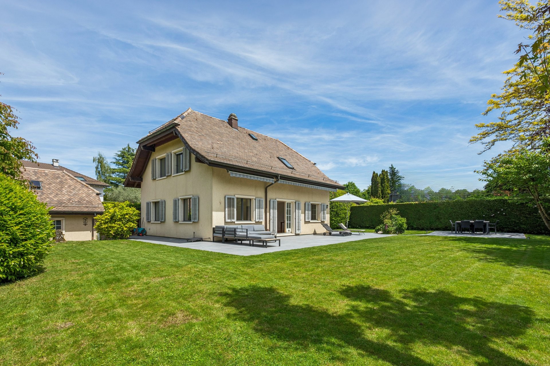 Gartenansicht eines Einfamilienhauses mit Terrasse
