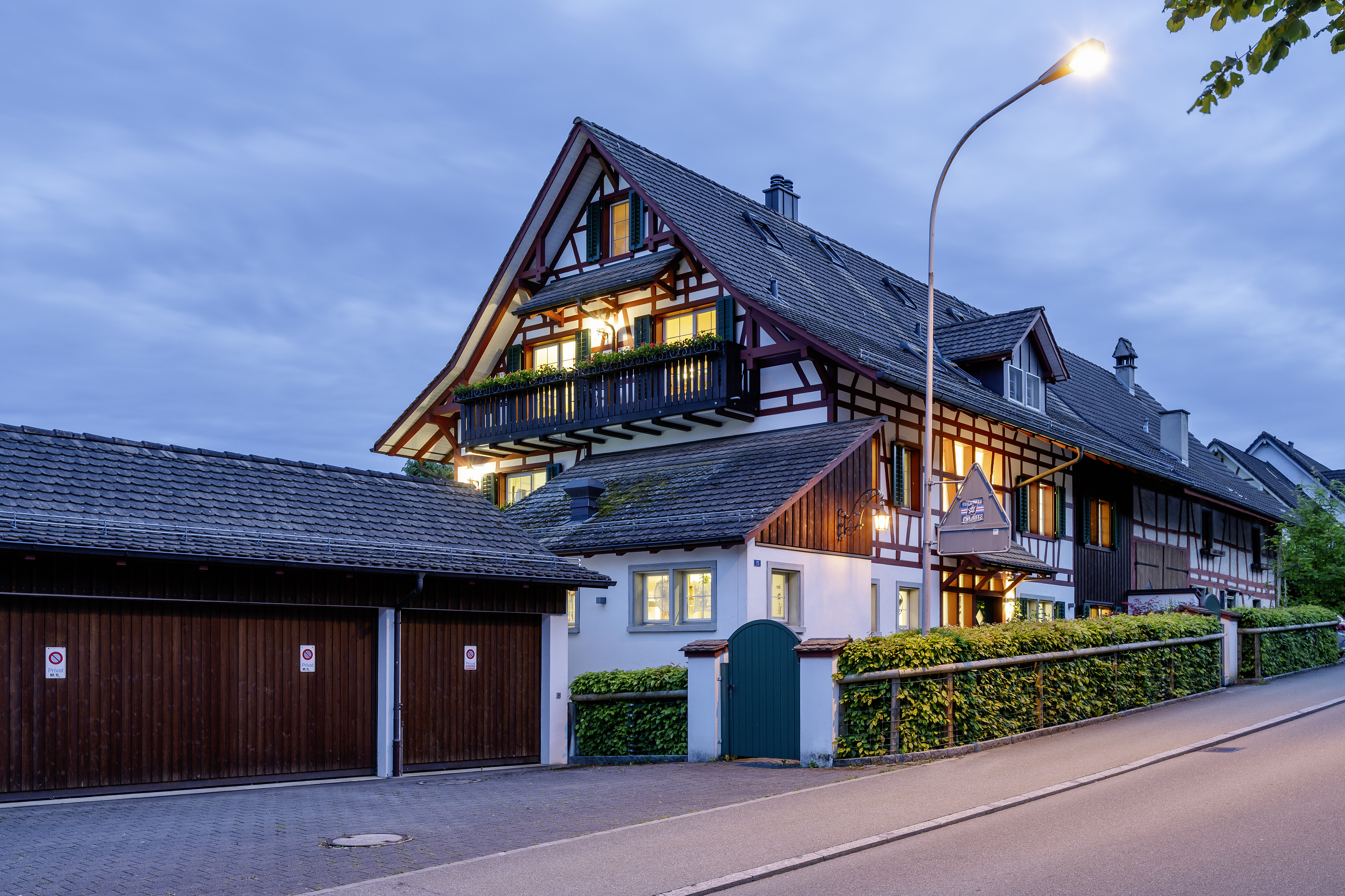 Alpenhaus mit Fachwerk und Satteldach bei Dämmerung