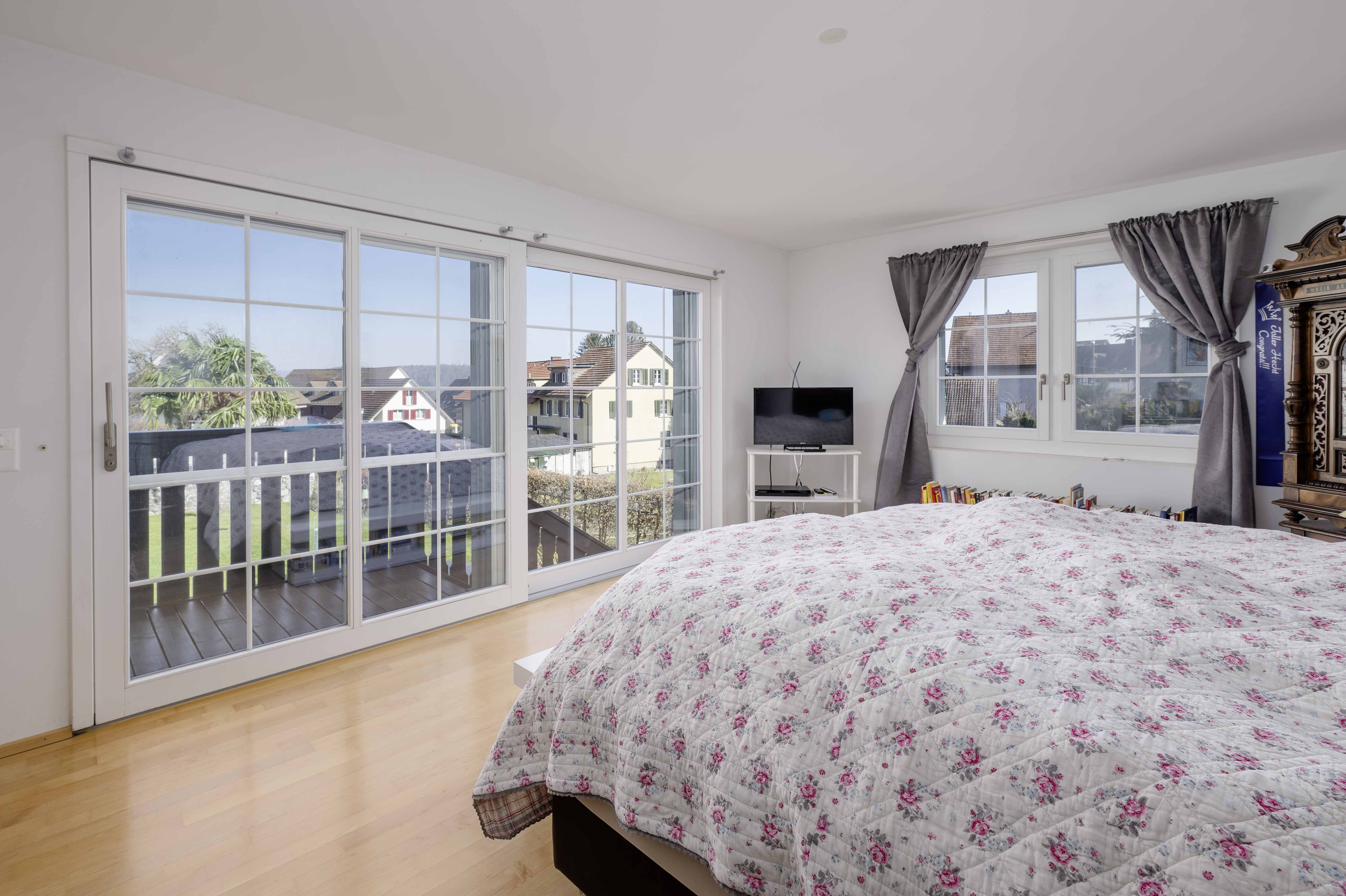 Helles Schlafzimmer mit Balkon und Blick ins Wohngebiet