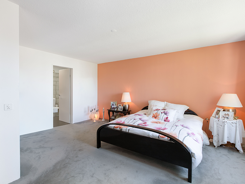 Helles Schlafzimmer mit peachfarbener Akzentwand